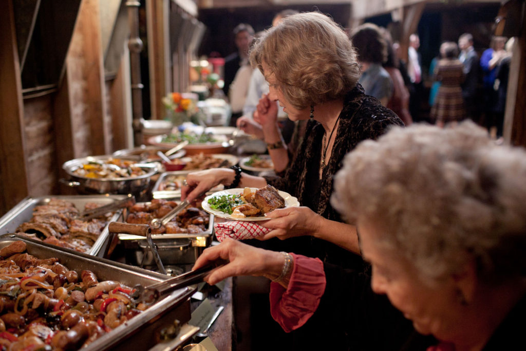 woman deciding what to eat at buffet food table