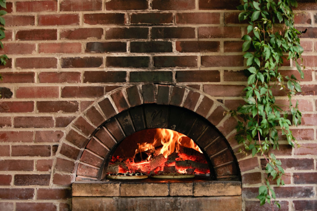 brick oven firing pizzas