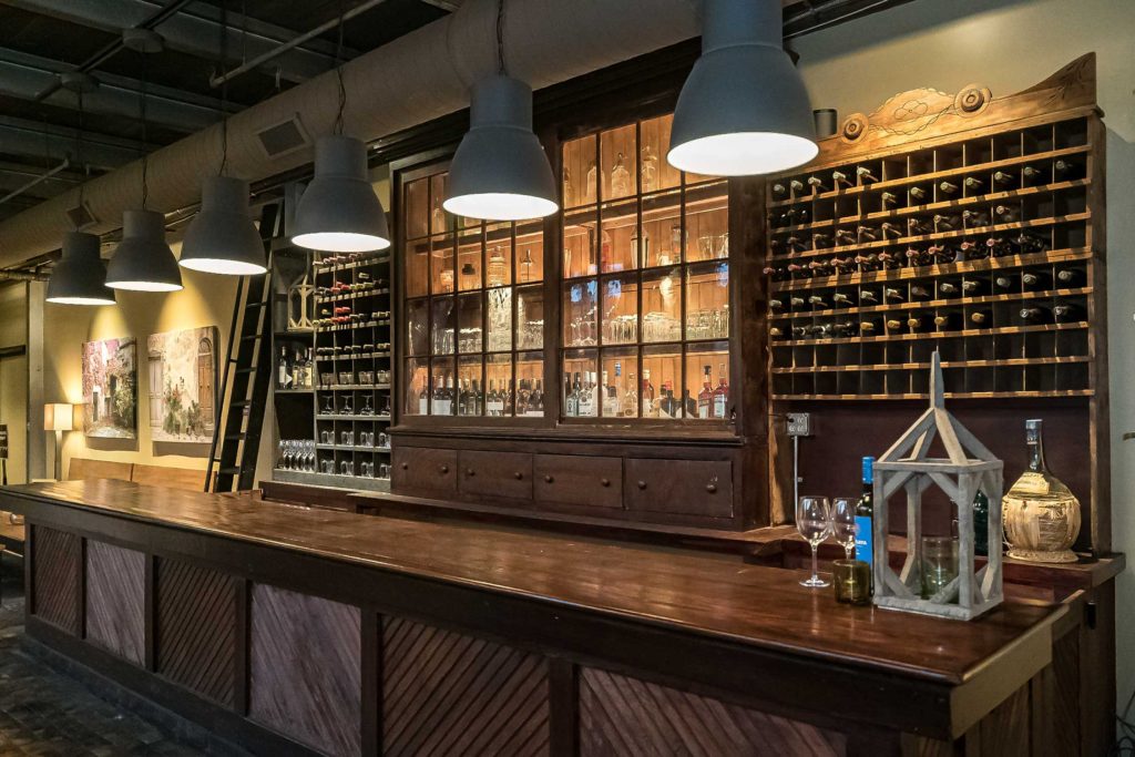 wine bottles and glass cabinet behind bar