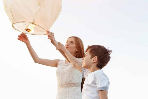 two young children holding sky lantern